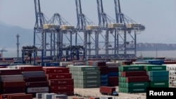 Sebuah truk melintasi deretan peti kemas di pelabuhan Ningbo, provinsi Zhejiang (9/7). Pertumbuhan ekonomi China melamban ke tingkat terendah sejak 1991