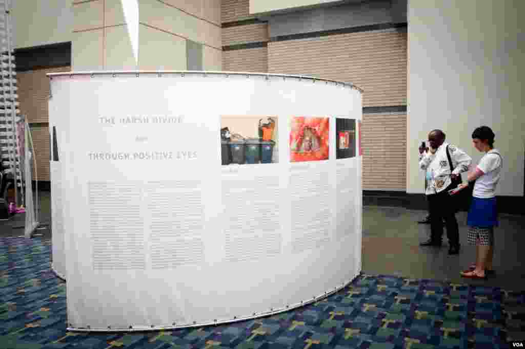Attendees view works of art and biographical stories in the rotunda outside the conference.