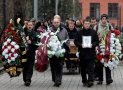 FILE - Friends and relatives take part in the funeral ceremony of Sergei Magnitsky at a cemetery in Moscow, Nov. 20, 2009.