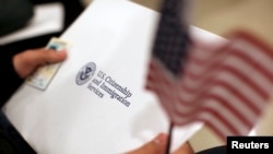 2013年1月30日，一名男子在加州旧金山参加公民宣誓仪式时接过公民证。（资料照片）