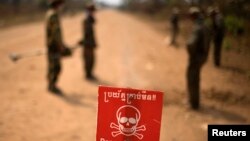 រូបឯកសារ៖ សញ្ញា«ប្រយ័ត្នគ្រាប់មីន‍» ត្រូវបាន​ដាក់​នៅ​លើ​ផ្លូវ​លំមួយ ខណៈពេលដែលទាហានកម្ពុជាកំពុងរក​គ្រាប់មីនដែលនៅសេសសល់ នៅ​ជាង​ខេត្ត​ប៉ៃលិន កាលពីថ្ងៃទី១៣ ខែកុម្ភៈ ឆ្នាំ២០០៩។ (REUTERS/Adrees Latif)