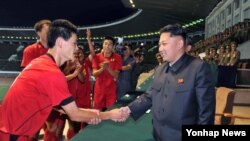 북한 김정은 국방위원회 제1위원장(오른쪽)이 '청년절'인 지난 8월 김일성 경기장에서 '횃불컵' 1급 남자축구 결승전을 관람하고 선수들과 인사하고 있다.