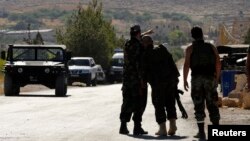 Lebanese army soldiers point towards the direction of the mountain where clashes is taking place with Islamist militants, near the entrance leading to Arsal, near the Syrian border in Lebanon, August 3, 2014. 