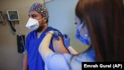  In this Oct. 9, 2020, file photo, a health worker, right, administers the first dose of a COVID-19 vaccine currently on phase III clinical trials to Cem Gun, an emergency medicine physician at the Acibadem Hospital in Istanbul.(AP Photo/Emrah Gurel, File)
