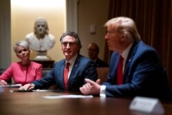 Michelle Kommer, commissioner of the North Dakota Department of Commerce, and North Dakota Gov. Doug Burgum listen as President Donald Trump speaks during a meeting about the coronavirus response, at the White House in Washington, May 13, 2020.