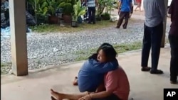 Watu waliopoteza ndugu zao wakijifariji katika kituo cha kulea watoto Thailand ambapo mtu mwenye silaha anadaiwa kuwauwa zaidi ya watu 30.