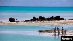Anak-anak bermain di karang berlumut dekat desa Ambo on South Tarawa, Kepulauan Pasifik Tengah, Kiribati (Foto: dok). Wilayah yang terdiri dari sekitar 33 kepulauan yang tingginya hanya beberapa meter dari permukaan air laut ini diperkirakan tidak dapat dihuni lagi dalam 30 hingga 60 tahun mendatang.
