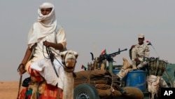 FILE - Gen. Mohammed Hamdan Dagalo, the deputy head of the military council sits on his vehicle surrounded by soldiers from the Rapid Support Forces, RSF, unit during a military-backed tribal rally, in the East Nile province, Sudan, June 22, 2019.