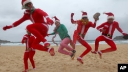 British travelers kick up their heels as they celebrate Christmas Day at Bondi Beach in Sydney, Australia, December 2012. (AP Photo/Rick Rycroft)