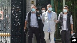 Hong Kong media businessman Jimmy Lai, center, who founded local newspaper Apple Daily, is arrested by police officers at his home in Hong Kong, Monday, Aug. 10, 2020. Lai was arrested Monday on suspicion of collusion with foreign powers under he new national security law.