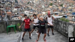 FILE - Youths perform a street dance style known as passinho for their social media accounts, in the Rocinha favela of Rio de Janeiro, April 17, 2024. 