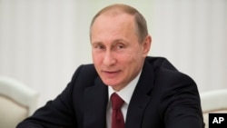 FILE - Russian President Vladimir Putin smiles during a meeting with foreign ministers of the Shanghai Cooperation Organization in Moscow, Russia, June 3, 2015. 