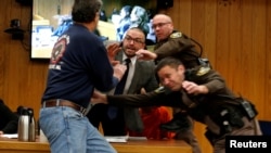 Randall Margraves, left, lunges at Larry Nassar (wearing orange) a former team USA Gymnastics doctor who pleaded guilty in November 2017 to sexual assault charges, during victim statements of his sentencing in the Eaton County Circuit Court in Charlotte, 