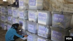 Petugas pemilu menandai kotak-kotak suara yang selesai dihitung di Kabul, Afghanistan.