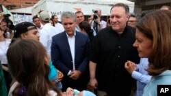 Le secrétaire d'État américain Mike Pompeo, deuxième à droite, écoute les migrants vénézuéliens dans un camp pour migrants, le 14 avril 2019.