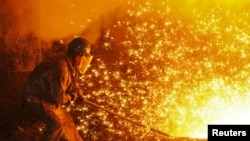 An employee works next to molten iron at a steel mill of Dongbei Special Steel in Dalian, Liaoning province, China, July 17, 2018. (Reuters Photo)