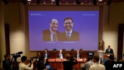 Thomas Perlmann, le secrétaire du Comité Nobel, à côté d'un écran affichant les lauréats du Prix Nobel de physiologie ou médecine 2021 David Julius et Arden Patapoutian, lors d'une conférence de presse à l'Institut Karolinska de Stockholm, le 4 octobre 2021.