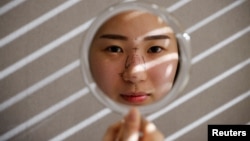 FILE - Ryu Han-na poses for photographs before undergoing nose plastic surgery at WooAhIn Plastic Surgery Clinic in Seoul, South Korea, December 17, 2020. (REUTERS/Kim Hong-Ji)