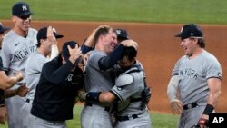 New York Yankees pitcher Corey Kluber, third from right, celebrates with catcher Kyle Higashioka, second from right, and the rest of the team after throwing a no-hitter against the Texas Rangers in a baseball game in Arlington, Texas, May 19, 2021. (AP Photo/Tony Gutierrez)
