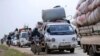 FILE - Syrians flee the advance of government forces towards the Turkish border, in Idlib province, Syria.