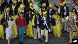 Seorang perempuan tak dikenal (baju merah) ikut bergabung bersama kontingen India di samping pembawa bendera Sushil Kumar, dalam pembukaan olimpiade di London (27/7). 
