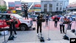 Members of the NY Phil Bandwagon, from left, violinist Fiona Simon, countertenor and producer Anthony Roth Costanzo, violinist Curtis Stewart and viola player Robert Rinehart perform in the Flushing neighborhood of the Queens borough of New York, Friday, (AP Photo/Mary Altaffer)