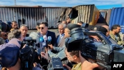 Prime Minister of Libya's U.N.-recognized Government of National Accord (GNA) Fayez al-Sarraj, flanked by journalists, visits the port in the capital Tripoli after it was hit by rocket fire, Feb. 19, 2020.