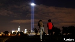 Annual Tribute in Light tested in New York's Lower Manhattan as a man takes a picture at Liberty State Park in Jersey City, New Jersey, September 9, 2013.