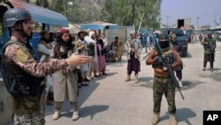 ទាហាន​ប៉ាគីស្ថាន​ម្នាក់​(ឆ្វេង) និង​ក្រុមប្រយុទ្ធ​តាលីបង់ ឈរ​យាម​នៅ​ផ្នែក​រៀងៗខ្លួន​នៅ​ចំណុច​ឆ្លងកាត់​ព្រំដែន​រវាង​ប៉ាគីស្ថាន​និង​អាហ្វហ្គានីស្ថាន​នៅ​ស្រុក Khyber ប្រទេស​ប៉ាគីស្ថាន​ថ្ងៃទី៥ ខែកញ្ញា ឆ្នាំ២០២១។