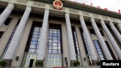 FILE - An officer stands outside the Great Hall of the People, the venue of National People's Congress, China's parliament, in Beijing.