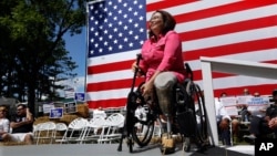 FILE - Democratic Rep. Tammy Duckworth, an Iraq War veteran who lost both of her legs in combat, acknowledges applause from supporters during a rally in Springfield, Illilois, Aug. 20, 2015. Some polls show ahead in her quest to unseat incumbent Republica