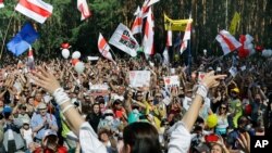 Svetlana Tikhanovskaya, candidate aux élections présidentielles, au premier plan, salue les gens lors d'une réunion de soutien, à Brest, à 326 km au sud-ouest de Minsk, en Biélorussie, le dimanche 2 août 2020. (AP Photo)