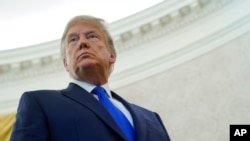 President Donald Trump listens to a reporter's question during a ceremony at the White House, Dec. 7, 2020.