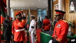 Kenyan military officers in ceremonial uniform stand guard and pay their respects as the body of former president Daniel arap Moi lies in state at the parliament building in downtown Nairobi, Kenya, Feb. 8, 2020.