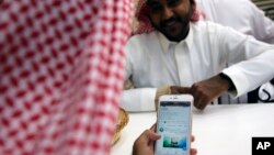 Seorang pria membaca Twitter Aramco di sebuah kafe di Jeddah, Arab Saudi, 3 November 2019. 