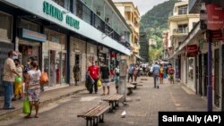 រូបឯកសារ៖ អ្នកថ្មើរជើង​ពាក់ម៉ាស់ ពេល​ពួកគេ​ដើរ​លើ​ផ្លូវ​នានា​នៅ​ទីក្រុង Victoria នៃ​ប្រទេស​សីស្ហែល (Seychelles) កាលពី​ថ្ងៃទី២៥ ខែកុម្ភៈ ឆ្នាំ២០២១។