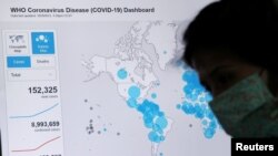 FILE - An employee from Sao Paulo state government works near a screen showing World Health Organization (WHO) dashboard about the coronavirus disease (COVID-19) outbreak around the world in Sao Paulo, Brazil, June 23, 2020. (REUTERS/Amanda Perobelli/File Photo)