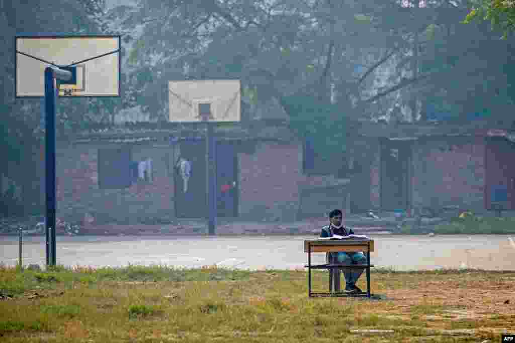 A school teacher conducts an online class near a basketball court at Swami Sivananda Memorial Institute in New Delhi.&nbsp;Keeping children at home and moving lessons online for days at a time during the peak of the smog crisis has become an annual ritual in the area.&nbsp;&nbsp;(Photo by Arun SANKAR / AFP)