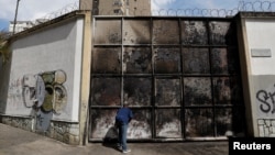 A resident looks at a burnt electrical substation after a massive blackout in Caracas, Venezuela, March 11, 2019.