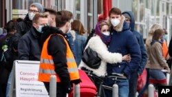 People wait in line for a COVID-19 test at a coronavirus test center in Cologne, Germany, Oct. 15, 2020.