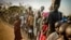 FILE - South Sudanese refugees wait in line to get food at Dzaipi transit camp in northern Uganda.
