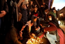 People gather for a candlelight vigil to remember the victims of the Ukraine plane crash, at the gate of Amirkabir University, which some of the victims of the crash were former students at, in Tehran, Iran, Jan. 11, 2020.