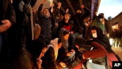 People gather for a candlelight vigil to remember the victims of the Ukraine plane crash, at the gate of Amrikabir University that some of the victims of the crash were former students of, in Tehran, Iran, Jan. 11, 2020. 