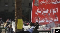 An Egyptian man rests on a fence in Tahrir Square in Cairo, Egypt, Sunday, Nov. 27, 2011. Egypt's activists are staging a massive protest in Cairo's Tahrir Square to press demands for the country's military rulers to step down. The Sunday rally, dubbed "L