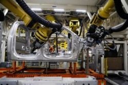In this Sept. 27, 2018, file photo robots weld the cab of a 2018 Ford truck at the Ford Rouge assembly plant in Dearborn, Michigan.