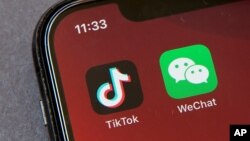 Icons for the smartphone apps TikTok and WeChat are seen on a smartphone screen in Beijing, Friday, Aug. 7, 2020. 