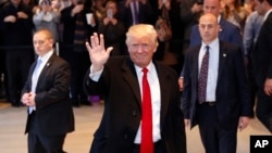 លោក​ប្រធានាធិបតី​ជាប់​ឆ្នោត Donald Trump បក់​ដៃ​ទៅ​កាន់​ក្រុម​មនុស្ស​នៅ​ពេល​លោក​ចាកចេញ​ពី​អគារ The New York Times នៅ​ក្រោយ​កិច្ចប្រជុំ​មួយ កាលពី​ថ្ងៃទី២២ ខែវិច្ឆិកា ឆ្នាំ២០១៦។