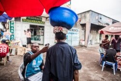 FILE - A health worker checks a man's temperature in Goma, July 31, 2019.