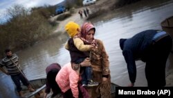 Dalam foto tertanggal 8/12/2012 pengungsi Suriah menyeberangi perbatasan Suriah menuju Turki melalui Sungai Orontes. UNHCR melaporkan perang di Suriah telah memaksa 3 juta orang mengungsi. 