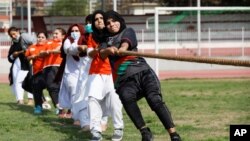 Women participants react as they pull a rope during a sports event in connection with the International Women's Day celebrations in Peshawar, Pakistan March 8, 2021.
